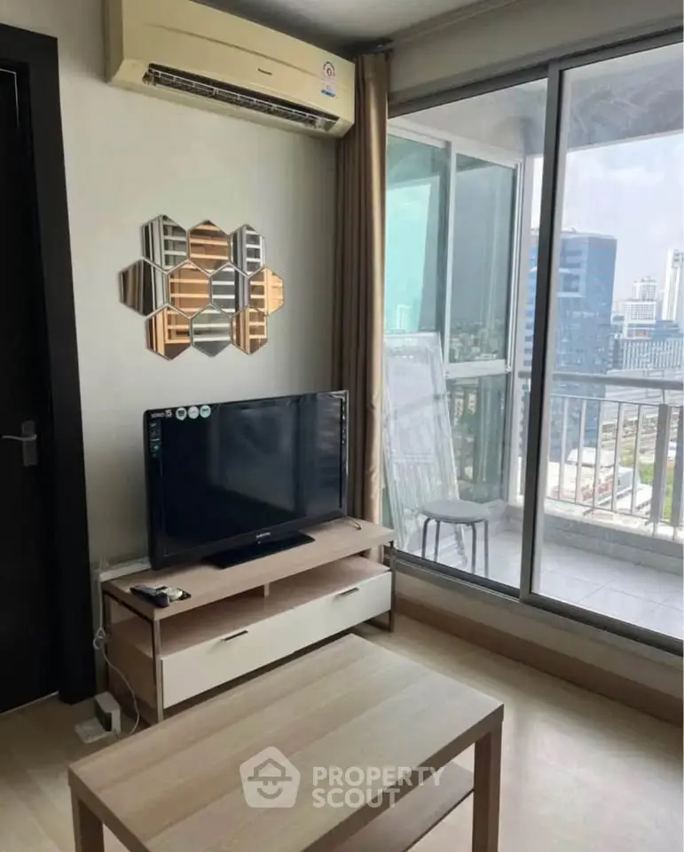 Modern living room with city view and balcony access, featuring sleek furniture and air conditioning.