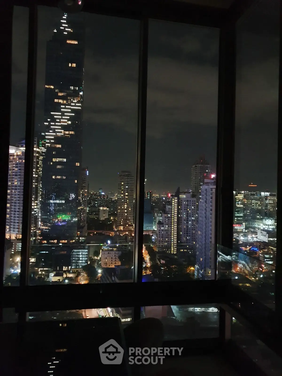 Stunning cityscape view from high-rise apartment window at night.