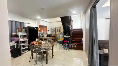 Spacious open-plan living area with dining table and staircase, perfect for modern family living.