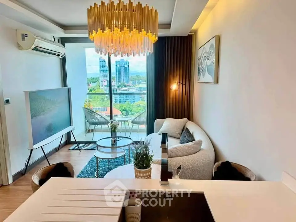 Modern living room with elegant chandelier and city view, featuring cozy seating and stylish decor.