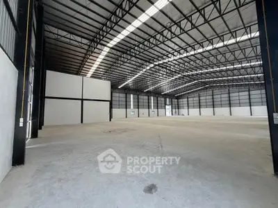 Spacious industrial warehouse with high ceilings and ample natural light, perfect for storage or manufacturing.
