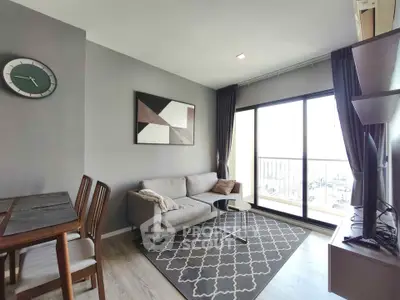 Modern living room with stylish decor and large window offering natural light and city view.