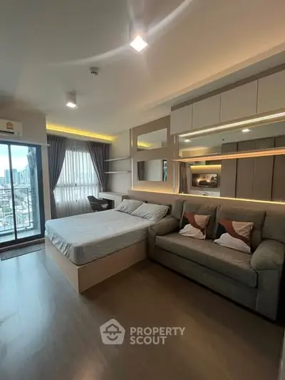 Modern studio apartment with stylish decor and city view balcony.