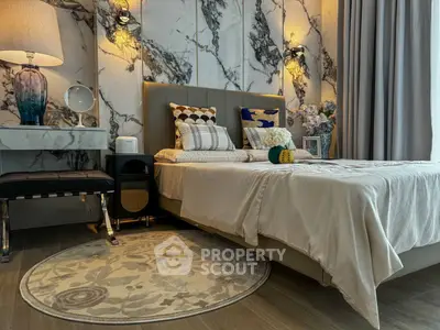 Luxurious bedroom with elegant decor and marble accent wall, featuring plush bedding and stylish lighting.