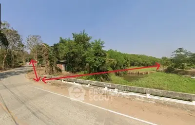Scenic land plot with lush greenery and water feature, ideal for development.