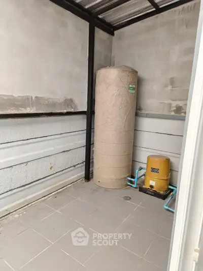 Utility room with water tank and pump in modern property