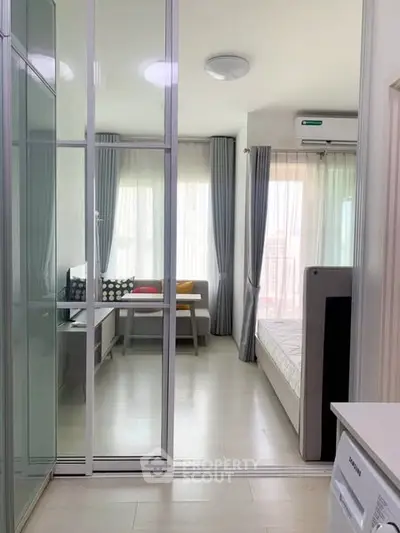 Modern studio apartment with glass partition and bright natural light