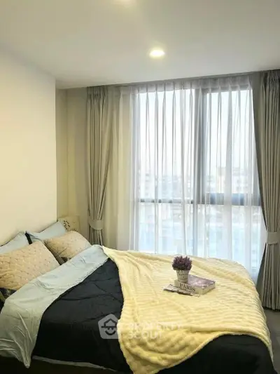 Cozy bedroom with large window and elegant curtains, perfect for relaxation and comfort.