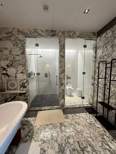 Luxurious marble bathroom with bathtub and glass shower enclosure