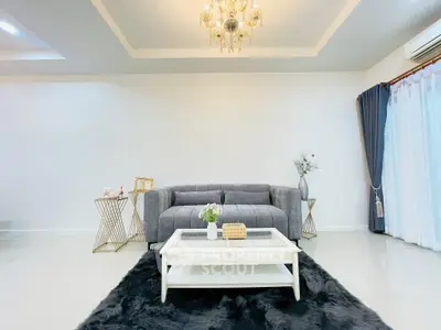Elegant living room with plush gray sofa, chic chandelier, and modern decor.
