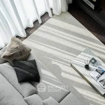 Stylish modern living room with cozy gray sofa and elegant coffee table, bathed in natural light.