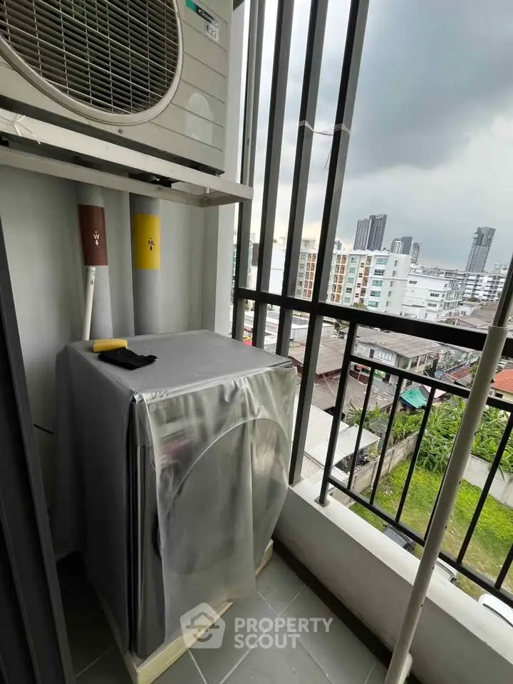 Compact balcony with washing machine and city view, ideal for urban living convenience.