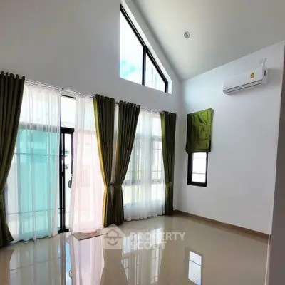 Spacious living room with high ceiling and large windows for natural light