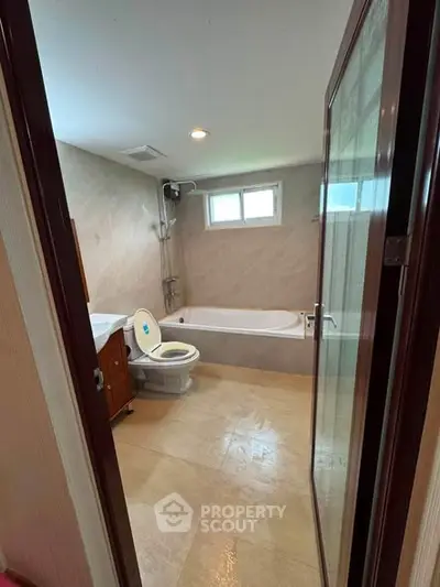 Spacious bathroom with bathtub and modern fixtures in a well-lit setting.