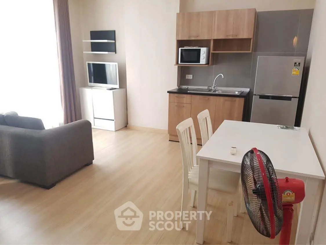 Modern studio apartment with open kitchen and cozy living area, featuring sleek appliances and stylish furniture.