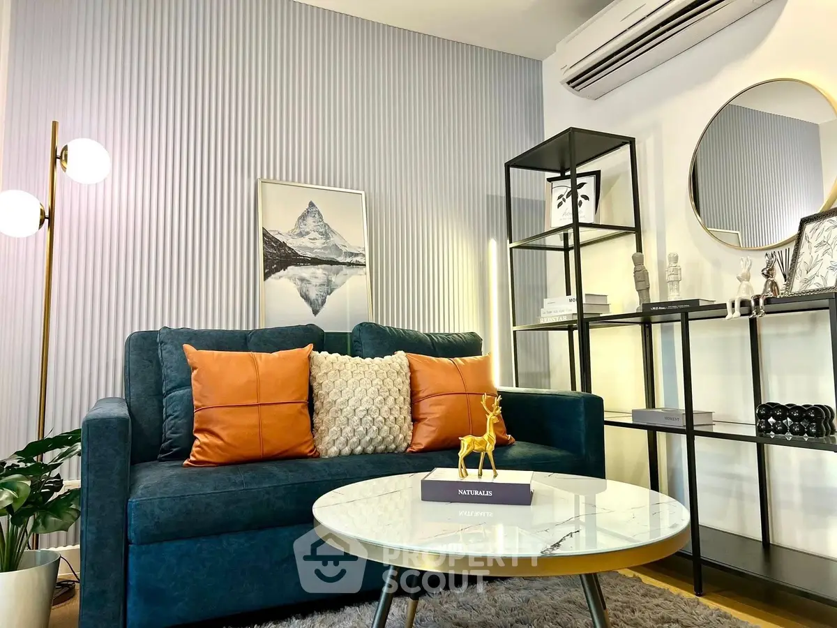 Stylish living room with modern decor, blue sofa, and elegant shelving.