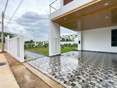 Modern home exterior with spacious driveway and lush green lawn