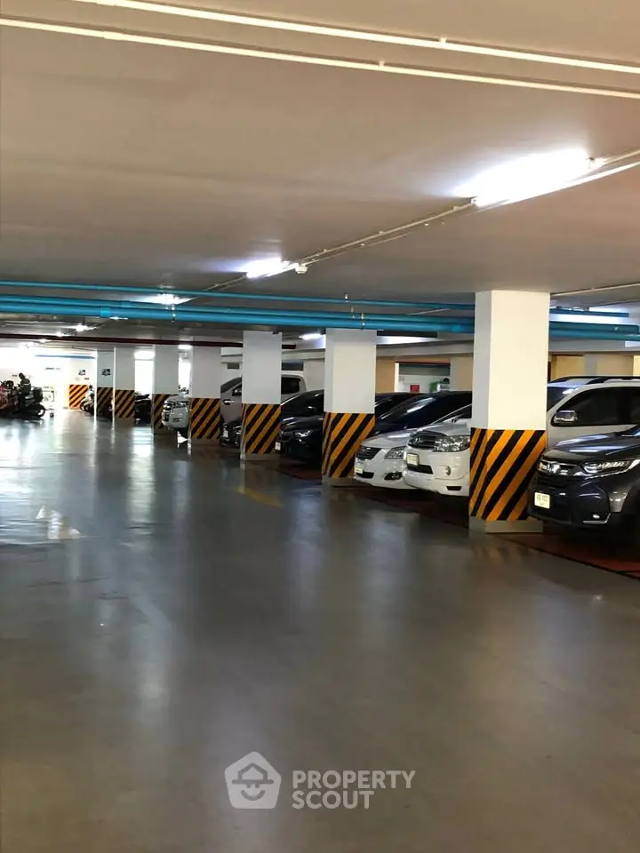 Spacious underground parking area with multiple vehicles parked in designated spots.