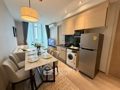 Modern open-layout kitchen and living room with dining area, featuring sleek appliances and elegant decor.
