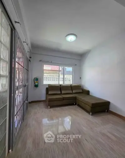 Spacious living room with modern sofa and large windows for natural light.