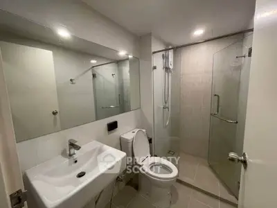 Modern bathroom with glass shower and sleek fixtures in a contemporary apartment.