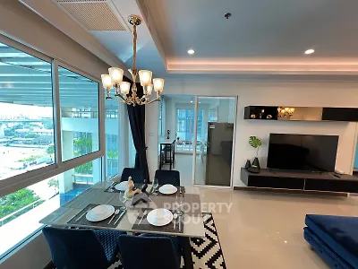 Modern living room with dining area and large windows offering city views