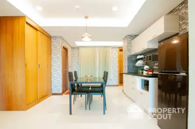 Modern kitchen with sleek white cabinetry and built-in appliances, complemented by a stylish dining area with elegant furnishings.