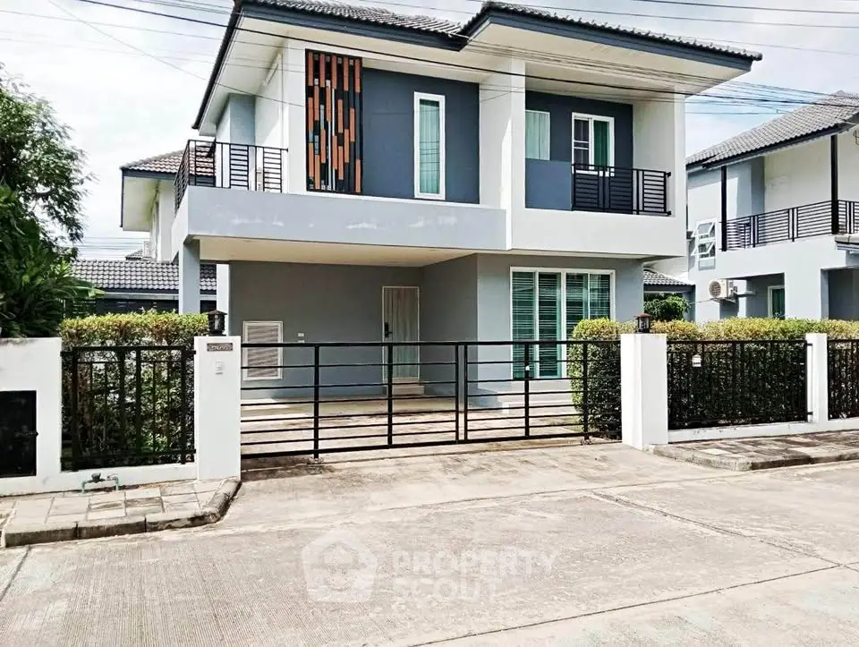 Modern two-story house with sleek design and gated entrance in a suburban neighborhood.