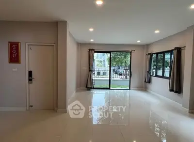 Spacious living room with large windows and glossy tile flooring