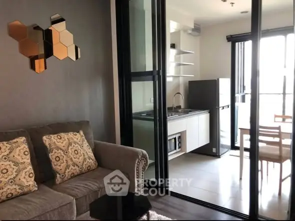 Modern apartment with open kitchen and cozy living area, featuring stylish decor and ample natural light.