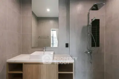 Modern bathroom with sleek shower and stylish vanity in contemporary apartment.