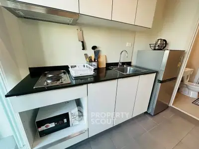 Modern compact kitchen with sleek cabinetry and appliances, ideal for urban living.