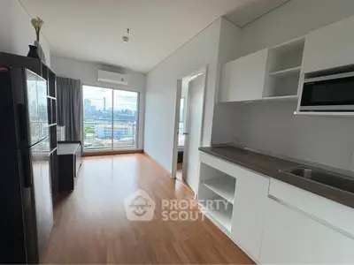 Modern apartment with open kitchen and city view, featuring sleek cabinetry and hardwood floors.