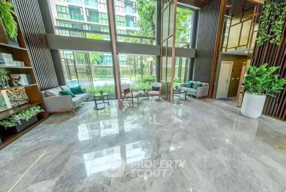 Luxurious lobby with modern seating and floor-to-ceiling windows overlooking lush greenery.