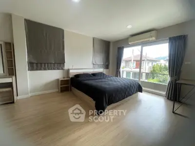 Spacious modern bedroom with large window and stylish decor