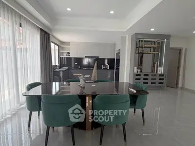 Elegant dining area with modern decor and green chairs in a spacious open-plan layout.