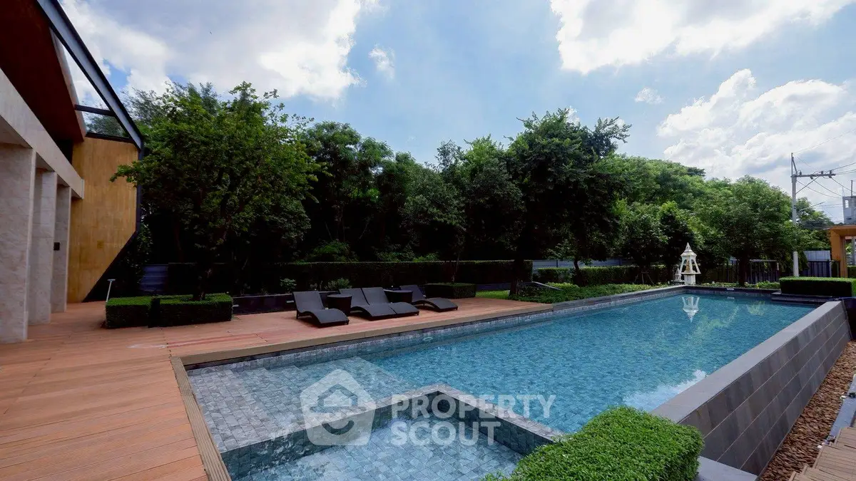 Luxurious outdoor pool area with modern design and lush greenery.