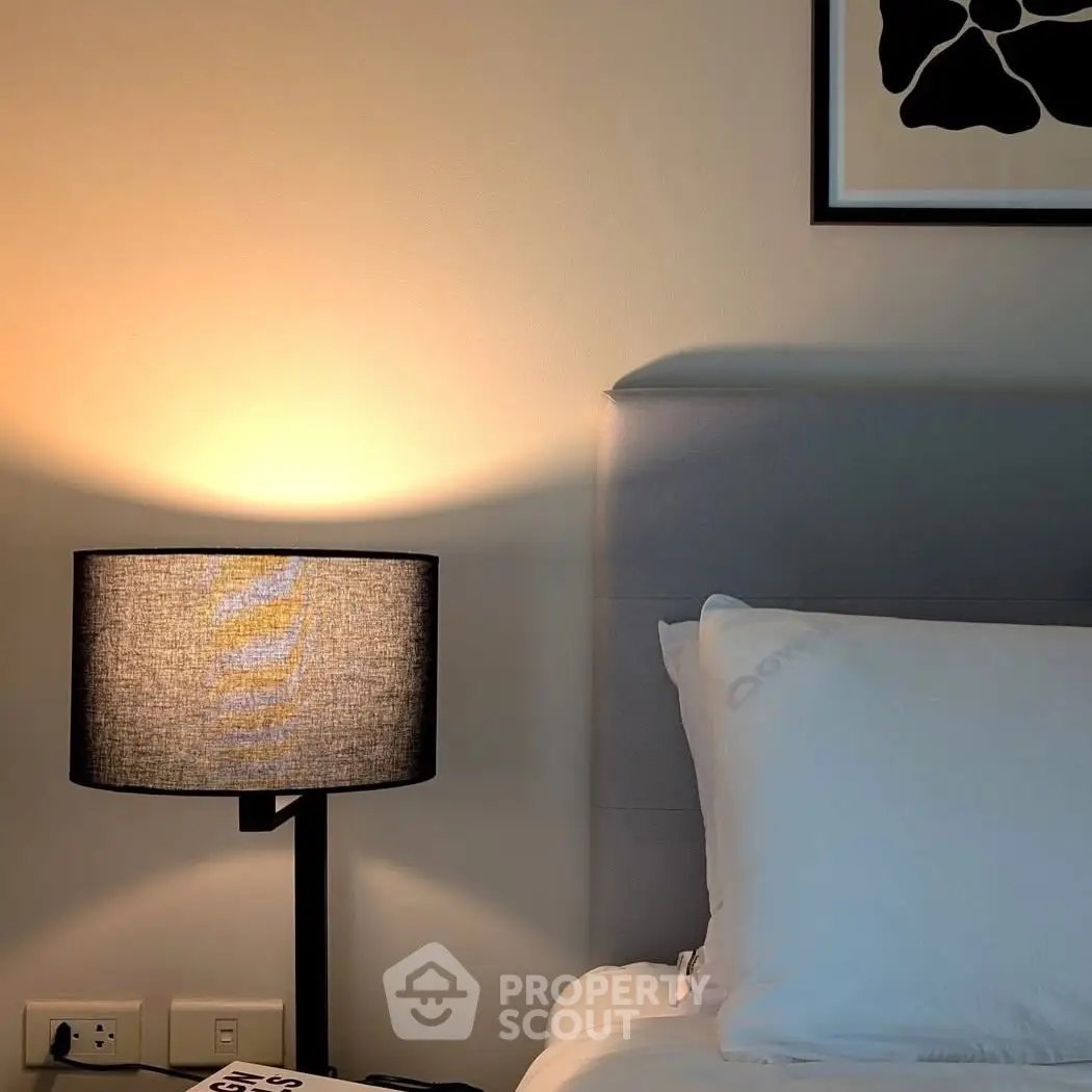 Cozy bedroom corner with stylish lamp and modern art decor
