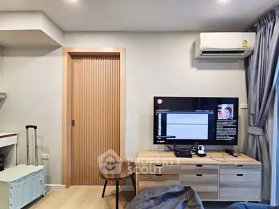 Modern living room with TV, air conditioning, and stylish furniture in a cozy apartment setting.