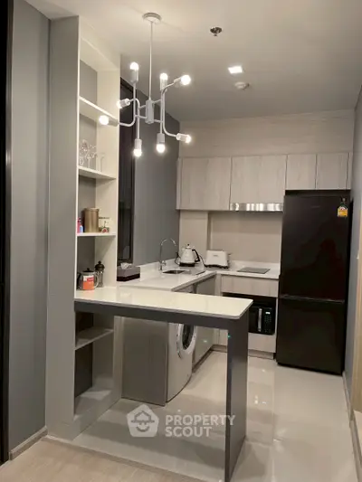 Modern kitchen with sleek design, featuring built-in appliances and stylish lighting.