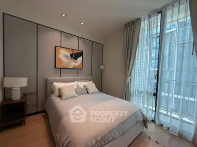 Elegant bedroom with modern decor and large window offering city view