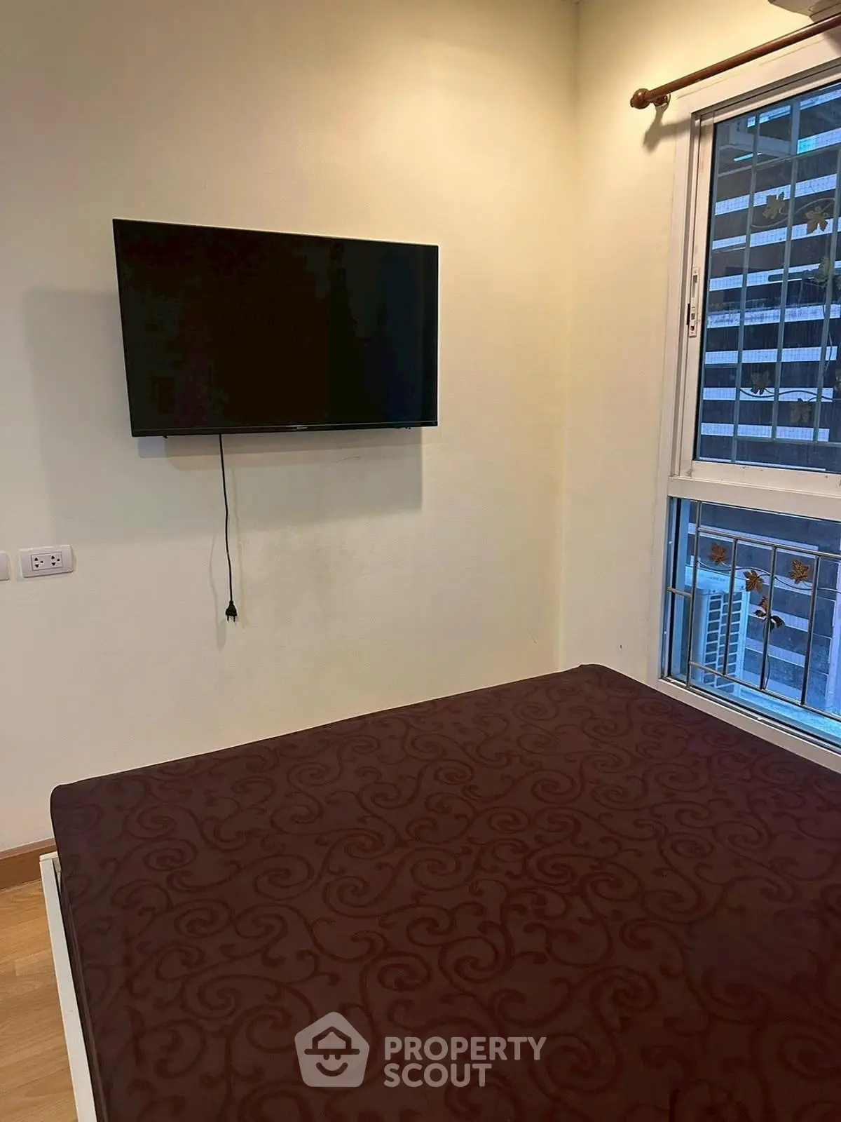 Cozy bedroom with wall-mounted TV and city view window