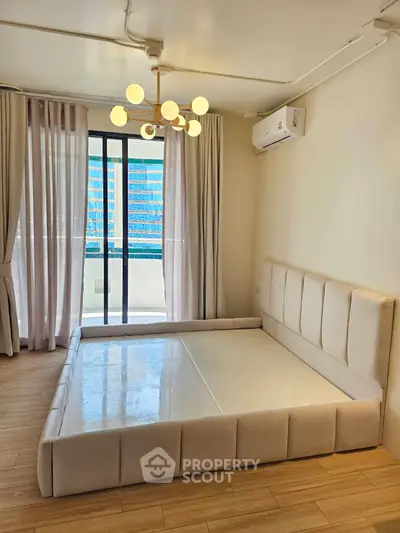 Modern bedroom with stylish bed frame and large window offering city view