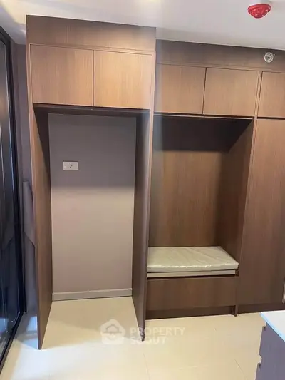 Modern storage space with sleek wooden cabinetry and built-in seating