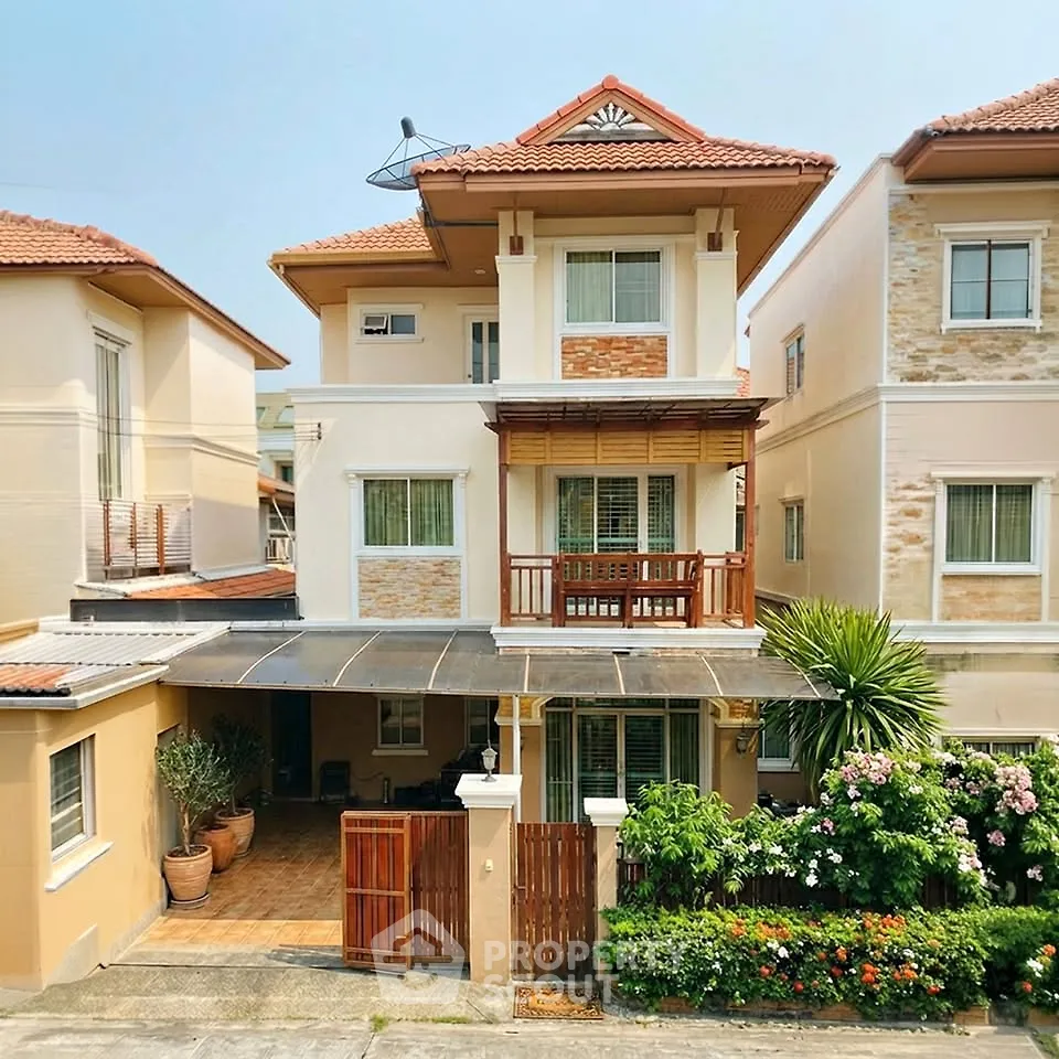 Charming two-story house with a tiled roof, lush garden, and spacious driveway in a serene neighborhood.