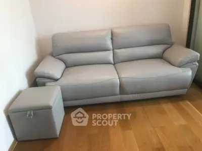 Modern living room with sleek grey sofa and wooden flooring