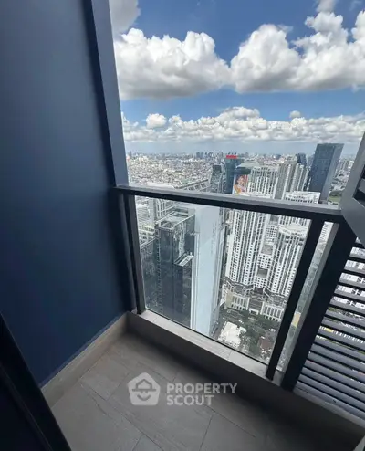 Stunning high-rise balcony with panoramic city view and clear blue skies.