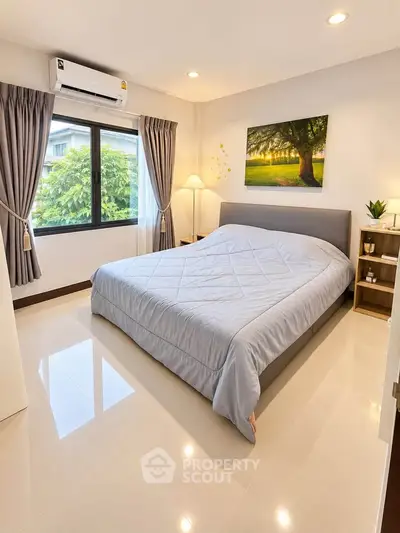 Bright and cozy bedroom with large window and modern decor