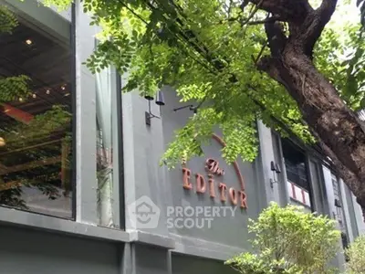 Modern building exterior with lush greenery and stylish signage.
