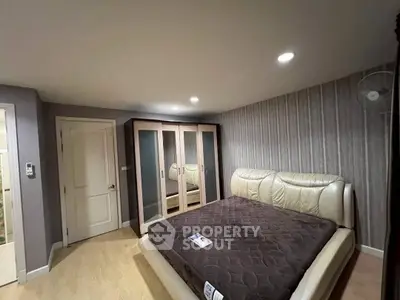 Spacious bedroom with modern design and large wardrobe in a stylish apartment.